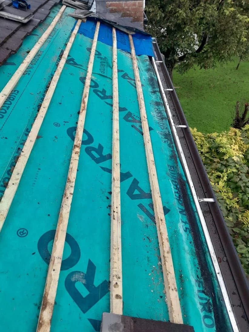 Roof replacement in progress — new slates being laid